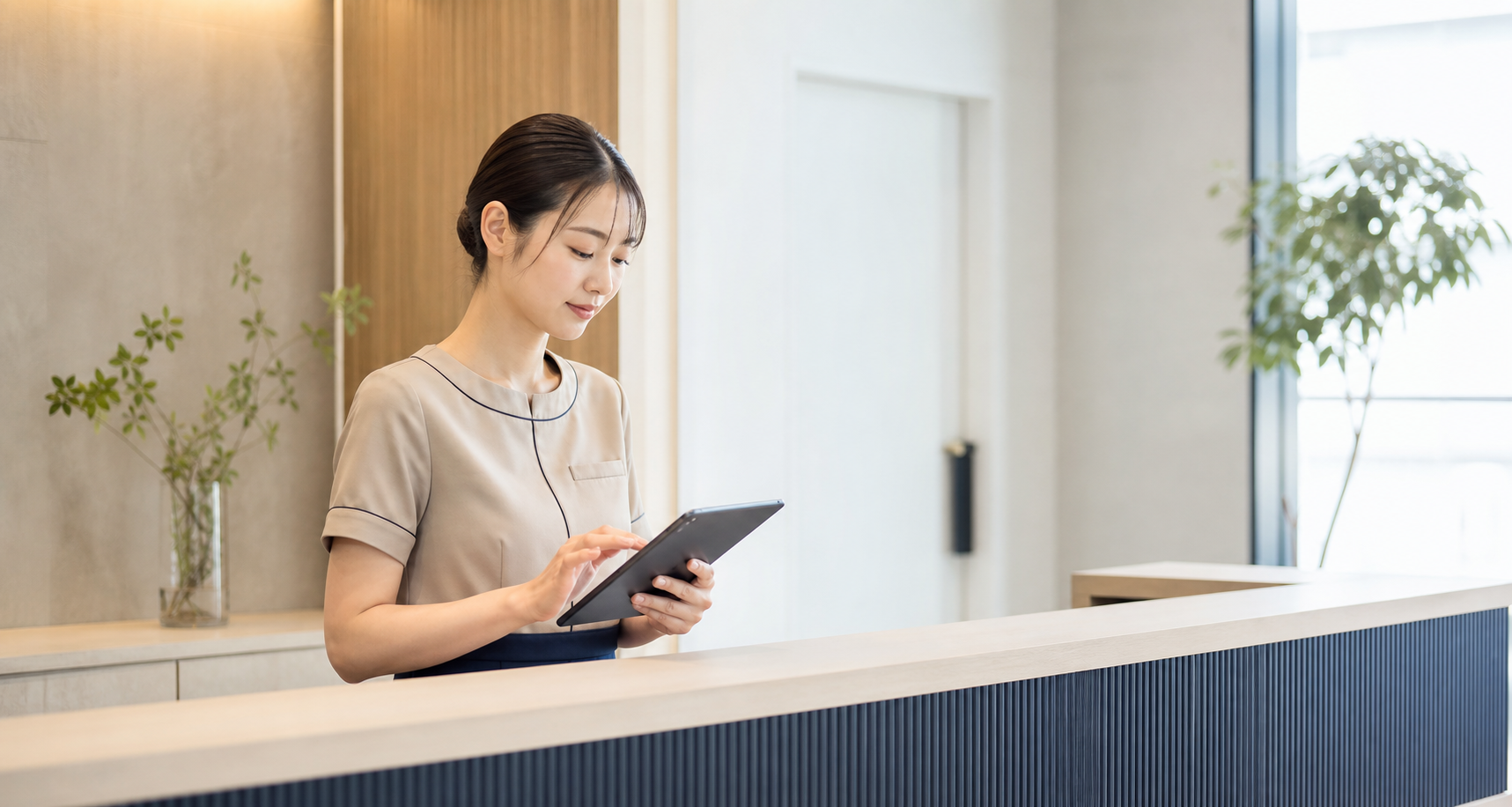タブレットで予約状況を確認するクリニック受付スタッフ